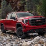 A red 2022 GMC Sierra 1500 AT4X is shown parked on a rocky trail during a 2022 GMC Sierra 1500 AT4 vs 2022 GMC Sierra 1500 AT4X comparison.