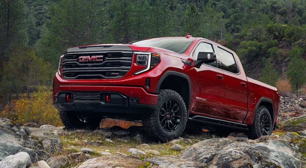 A red 2022 GMC Sierra 1500 AT4X is shown parked on a rocky off-road trail.