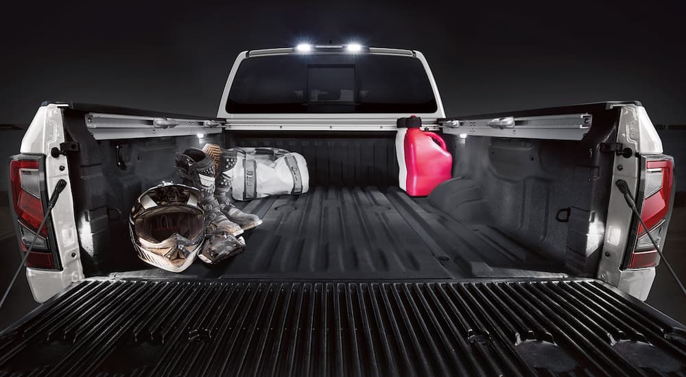 The bed of a white 2022 Nissan Titan XD is shown with the tailgate down.