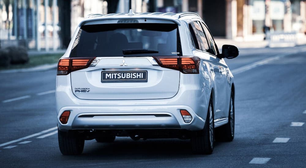 A silver 2022 Mitsubishi Outlander PHEV is shown from the rear after leaving a car dealer.