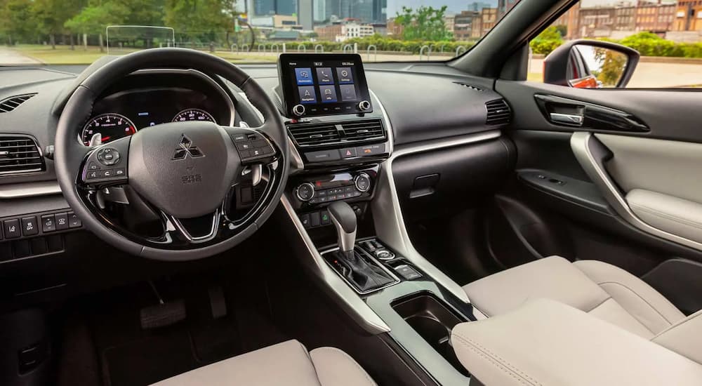 A view of the interior steering wheel and dashboard in a 2023 Mitsubishi Eclipse Cross is shown at a Mitsubishi dealer.