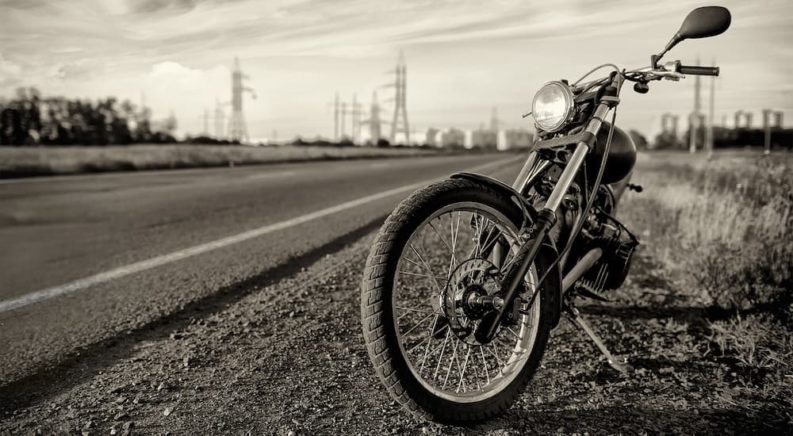 A motorcycle is shown parked on the side of a highway.