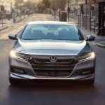 A silver 2020 Honda Accord is shown driving to a used Honda Accord dealer.