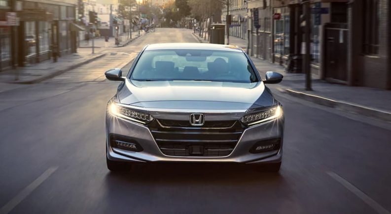 A silver 2020 Honda Accord is shown driving to a used Honda Accord dealer.