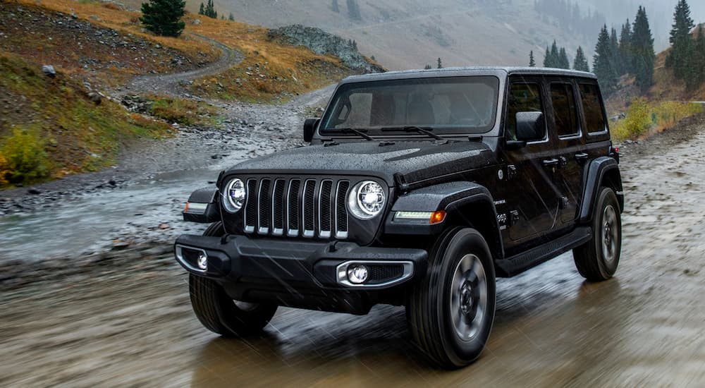 A grey 2018 Jeep Wrangler Unlimited is shown from the front on a trail.