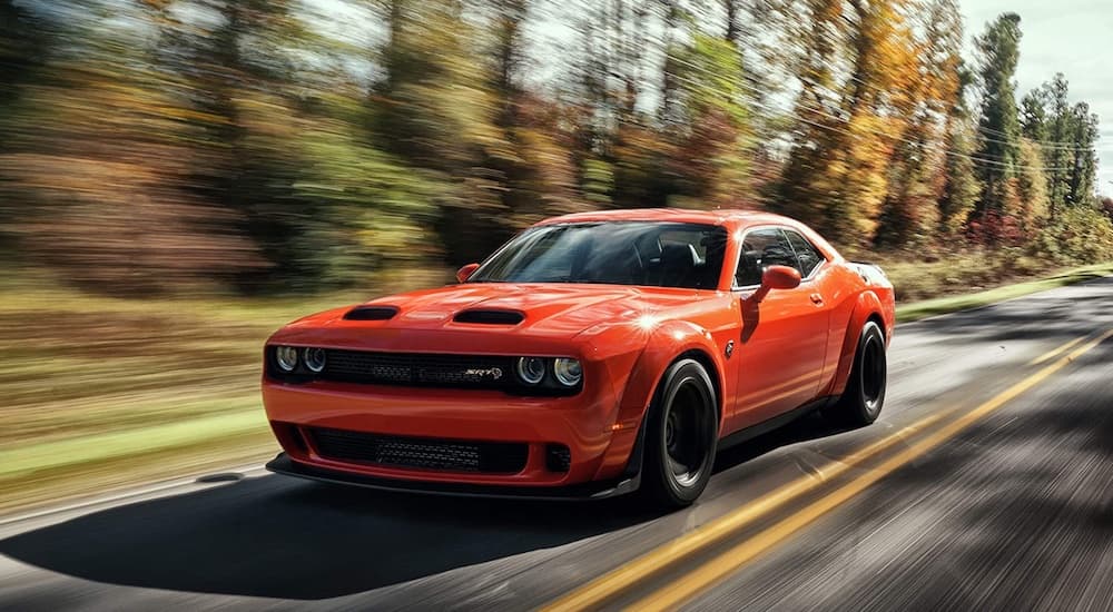 An orange 2022 Dodge Challenger Hellcat Widebody is shown from the front at an angle.