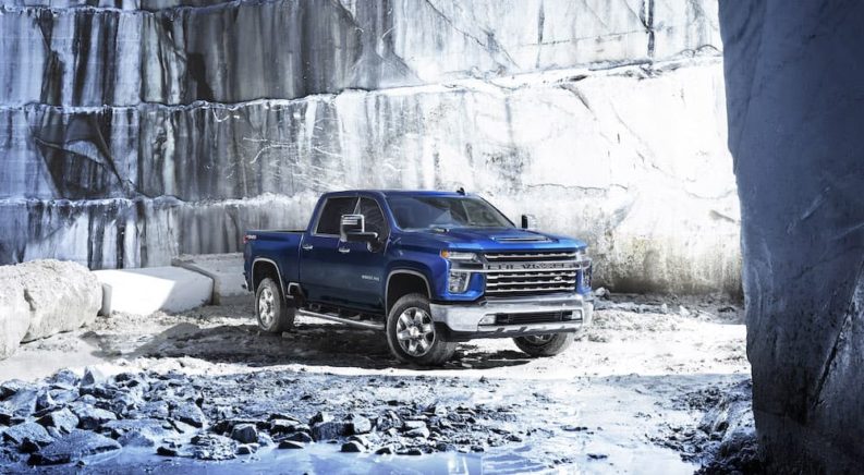 A blue 2022 Chevy Silverado 2500HD is shown from the front at an angle in a quarry.