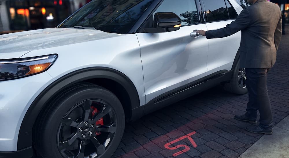 A man is shown opening the door of a silver 2022 Ford Explorer ST-Line.