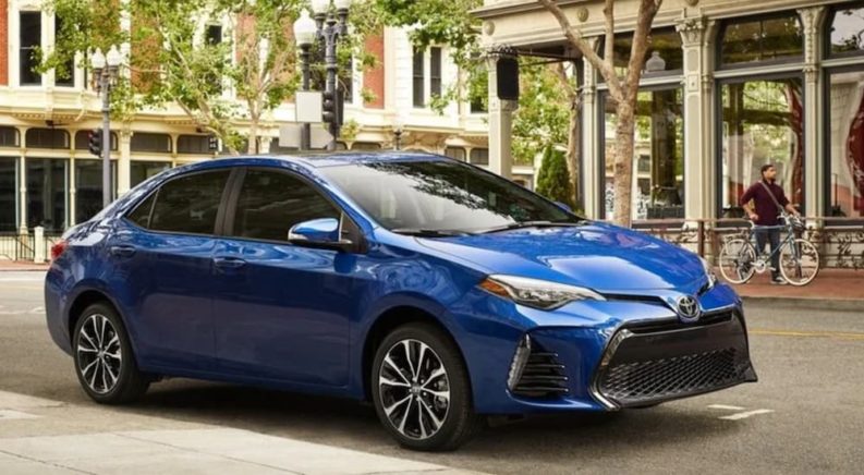 A blue 2019 Toyota Corolla is shown on a city street.