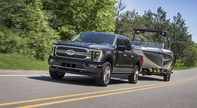 A grey 2022 Ford F-150 Limited is shown from the front while towing a boat during a 2022 Ford F-150 vs 2022 GMC Sierra 1500 comparison.