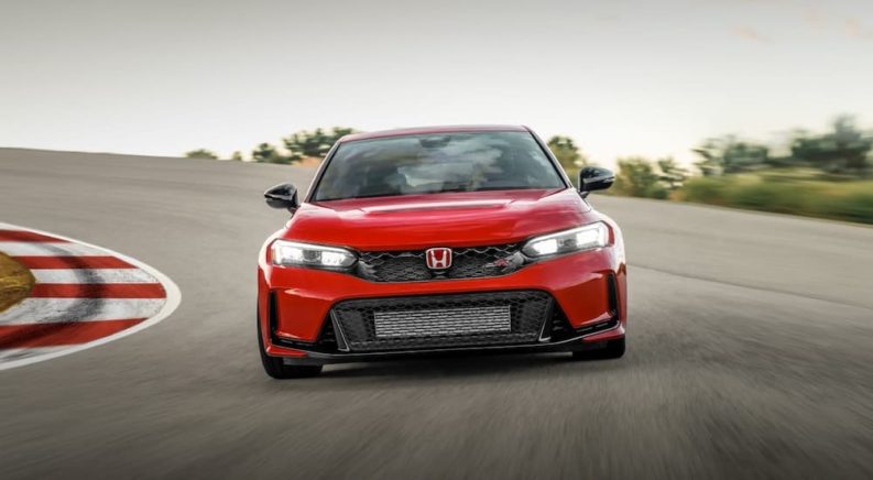 A red 2023 Honda Civic Type R is shown from the front while on a racetrack.