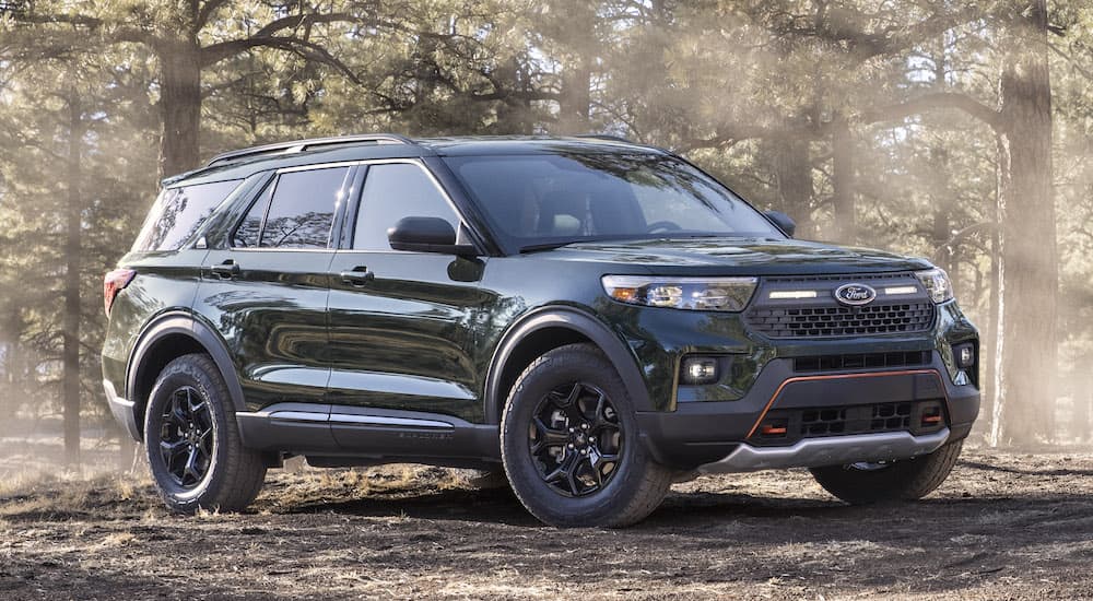 A green 2022 Ford Explorer Timberline is shown from the front at an angle while parked in a forest.
