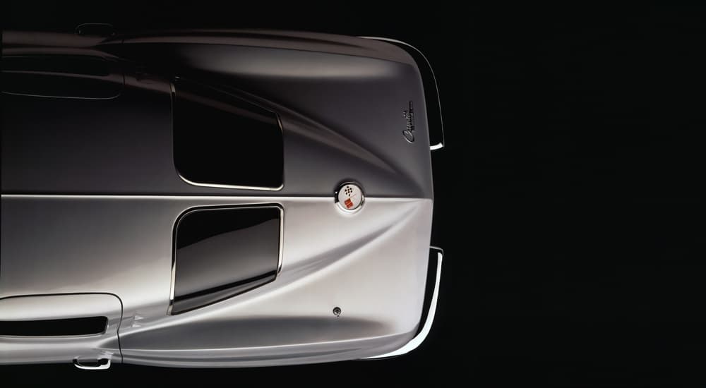 The rear end of a silver 1963 Chevrolet Corvette is shown from a high angle.