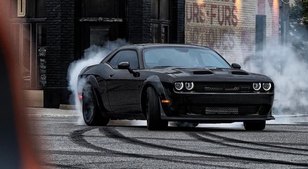 A black 2023 Dodge Challenger Hellcat Redeye is shown from the front while sliding after leaving a dodge dealer near you.
