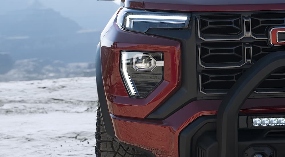 A close-up of the headlight of a reed 2023 GMC Canyon AT4x is shown.