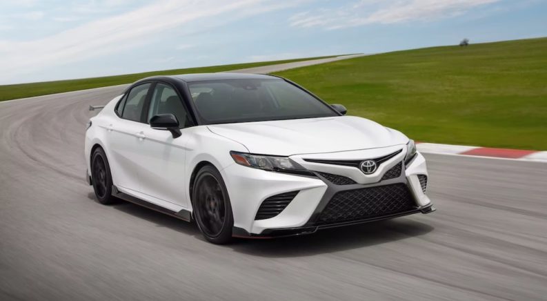 A white 2023 Toyota Camry TRD is shown from the front at an angle after leaving a dealer that handles online Toyota Camry sales.