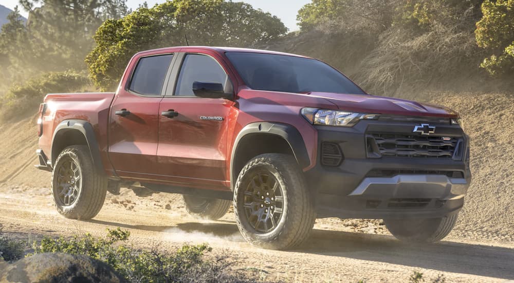 A red 2023 Chevy Colorado is shown from the side off-roading.