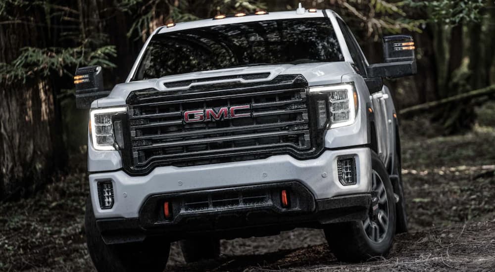 A white 2023 GMC Sierra 2500 HD AT4 is shown parked on a trail.