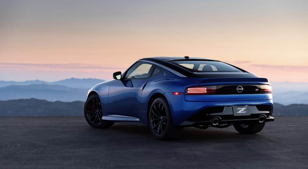 A blue 2023 Nissan Z is shown from a rear angle with a mountain view.