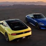 A yellow and a blue 2023 Nissan Z are shown parked in an empty lot.