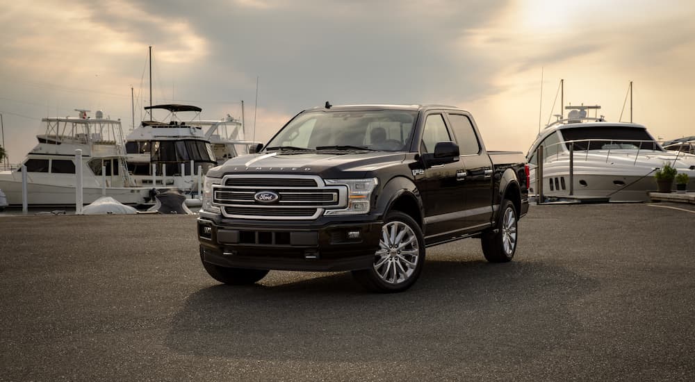 A black 2019 Ford F-150 Limited is shown parked at a marina.