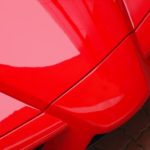 The nose of a red 2003 Ferrari Enzo is shown in close-up.