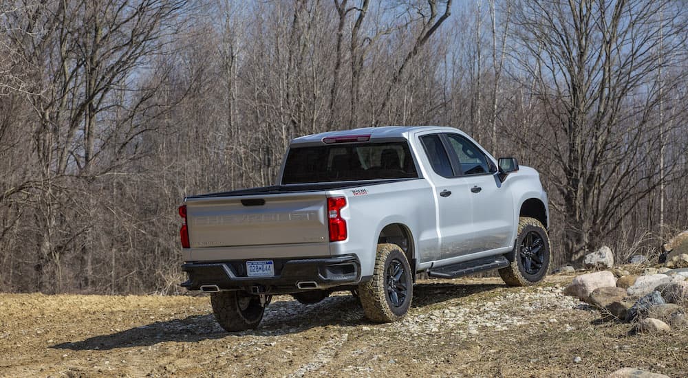 A grey 2022 Chevy Silverado 1500 Custom Trail Boss is shown from the rear after leaving a Chevy dealer.