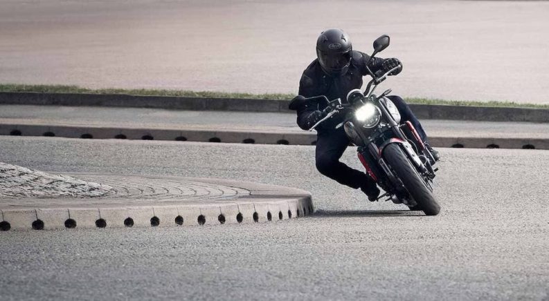 A person is shown riding the 2022 Motorcycle of the Nation, a black 2022 Triumph Trident 660.