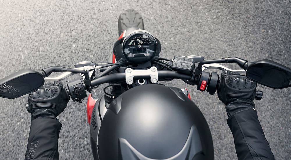 A close up shows the gauge and handlebars on a 2022 Triumph Trident 660.