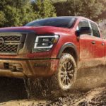 A red 2023 Nissan Titan is shown off-roading.
