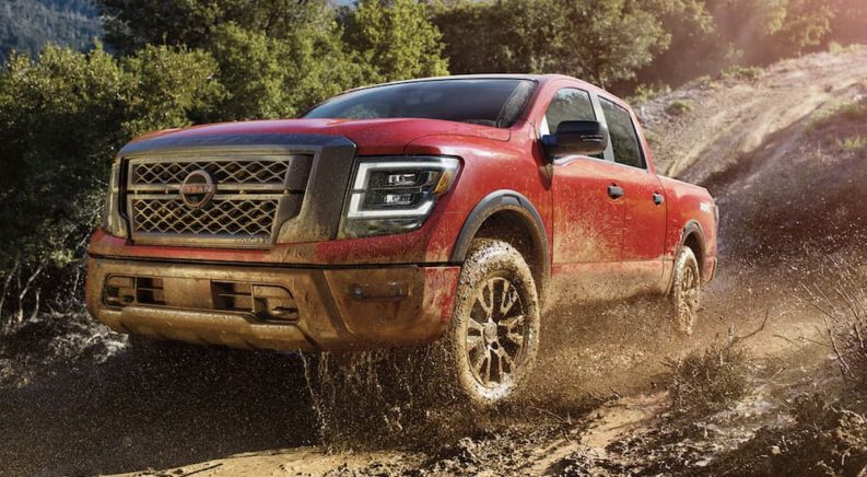 A red 2023 Nissan Titan is shown off-roading.