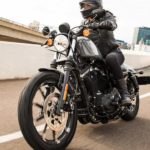A person is shown riding a 2022 Harley-Davidson Iron 883 after leaving a Harley-Davidson dealer.