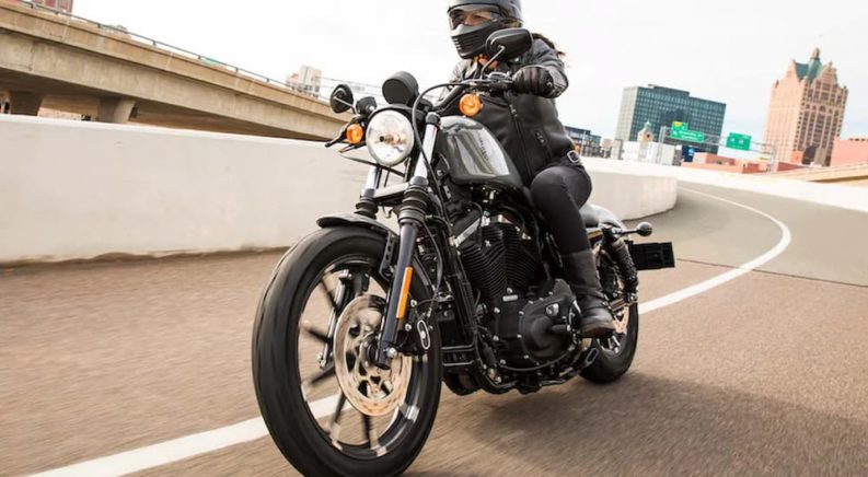 A person is shown riding a 2022 Harley-Davidson Iron 883 after leaving a Harley-Davidson dealer.