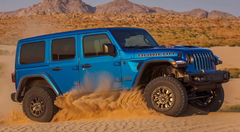 A blue 2022 Jeep Wrangler Rubicon 392 is shown off-roading in a desert.