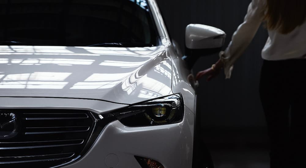 A close up shows the driver side headlight on a white 2018 Mazda CX-3.