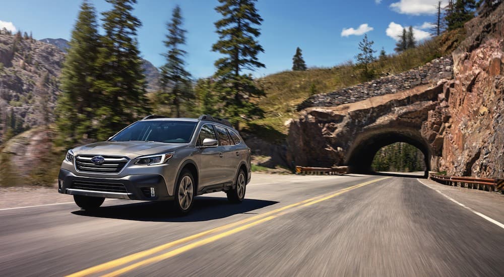 A popular vehicle for online Subaru Outback sales, a silver 2020 Subaru Outback, is shown driving out of a tunnel.