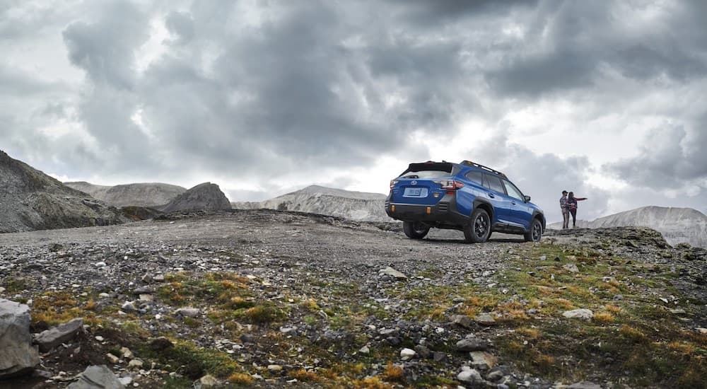 A blue 2022 Subaru Outback Wilderness is shown parked on a mountain trail.