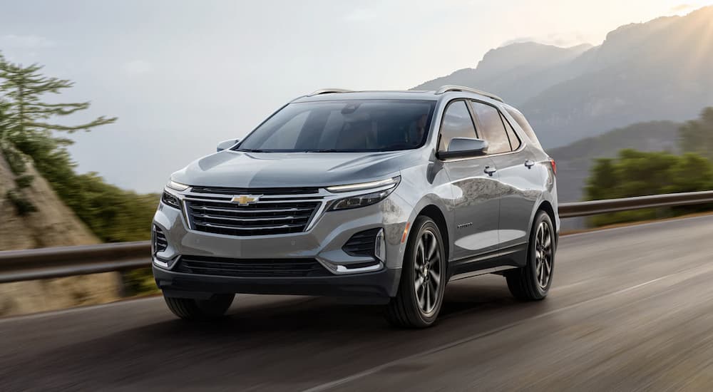 A grey 2022 Chevy Equinox is shown driving on an open road.