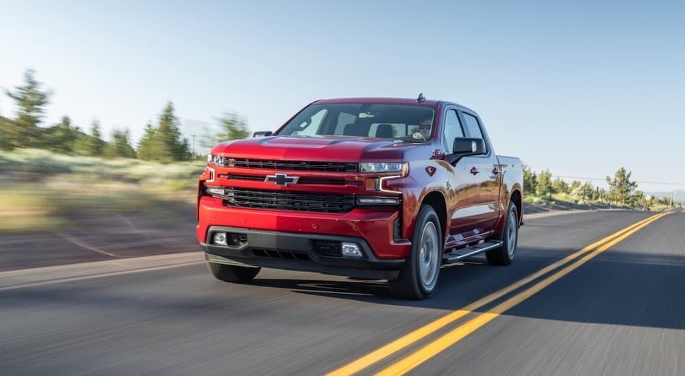 A red 2020 Chevy Silverado 1500 is shown driving to a used Silverado dealer.