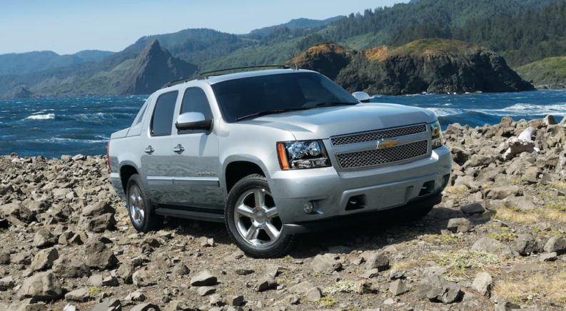 A grey 2012 Chevy Avalanche is shown parked on a beach.