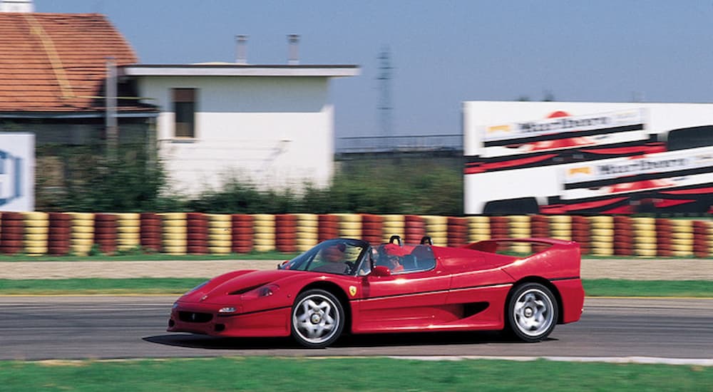 A red 1995 Ferrari F50 is shown driving on a track.