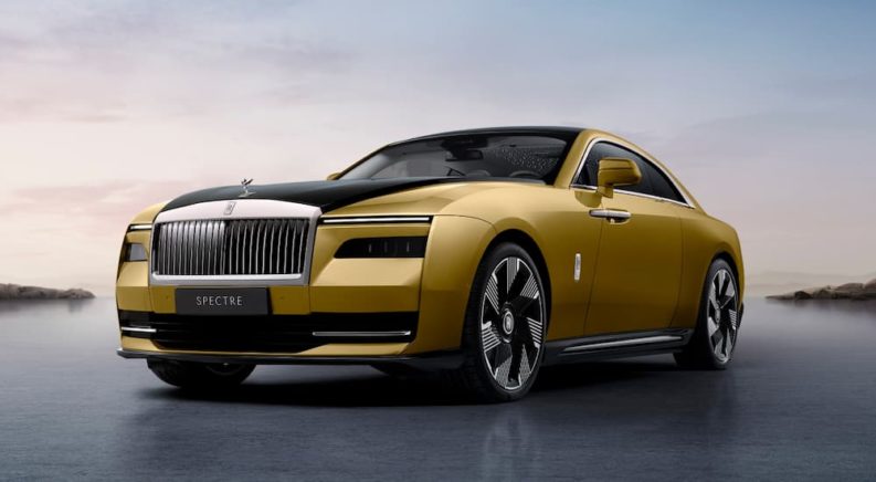 A yellow 2024 Rolls-Royce Spectre is shown from a front angle.