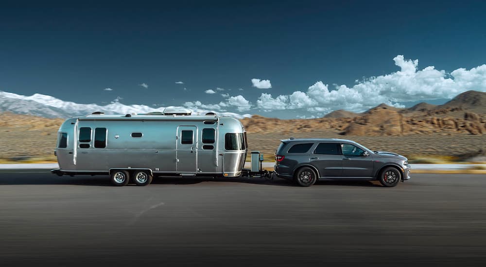 A silver 2022 Dodge Durango SRT 392 is shown from the side towing an Airstream trailer.