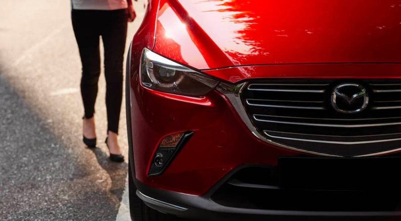 A red 2021 used Mazda CX-3 for sale is shown from the front in close up.