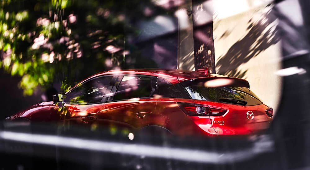 A red 2021 Mazda CX-3 is shown parked on a city street.