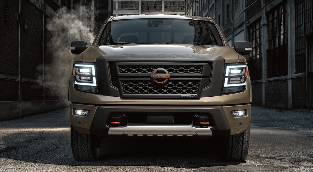A brown 2023 Nissan Titan is shown from the front parked on a city street.