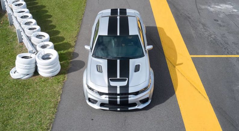 A silver 2023 Dodge Challenger Hellcat is shown from the front at a high angle after leaving a Dodge Charger dealer.