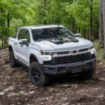 A white 2023 Chevy Silverado 1500 ZR2 Bison is shown from the front during a 2023 Chevy Silverado 1500 vs 2023 Ford F-150 comparison.