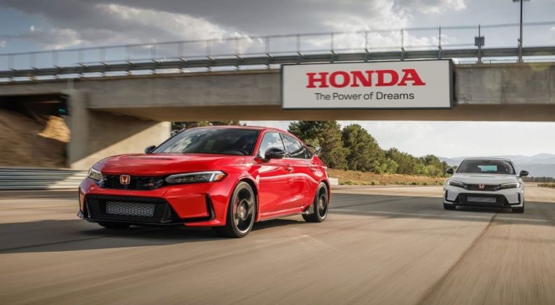 A red and a white 2023 Honda Civic Type R are shown on a racetrack.