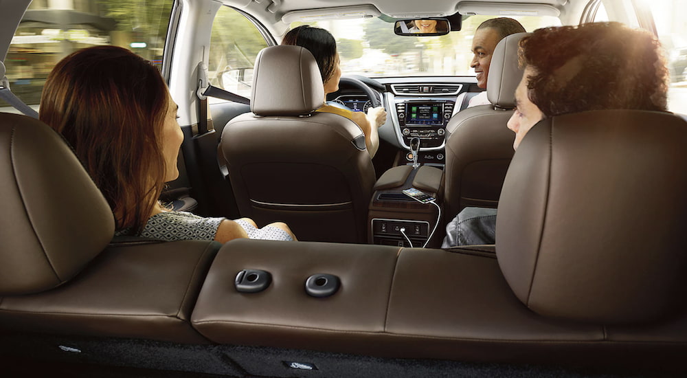 The brown interior of a 2023 Nissan Murano shows four passengers.